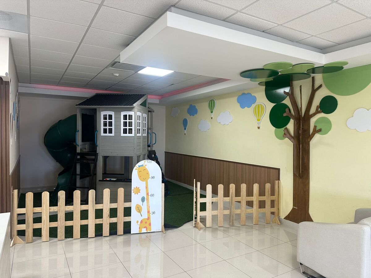 Área de juegos del consultorio con casita y decoración infantil.